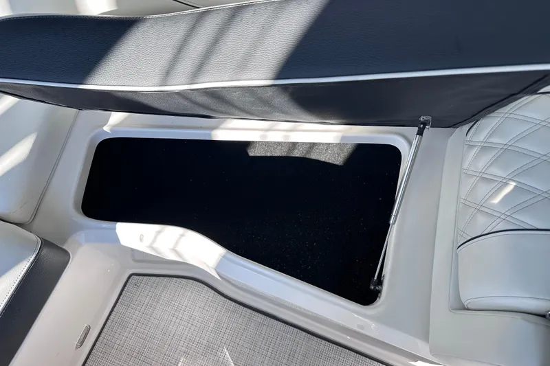 Slide: The Image of 2026 Regal LX4 boat interior storage compartment with cushioned seating and hydraulic lift. - 27