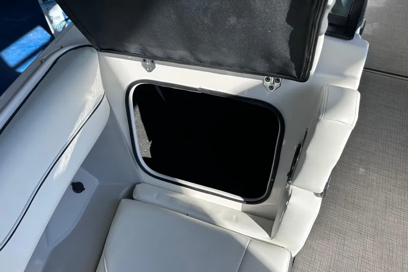 Slide: The Image of Open storage compartment in 2026 Regal LX4 boat with white seating. - 28