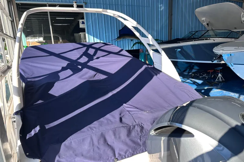Slide: The Image of Covered 2026 Regal LX4 boat in storage, with blue tarp and surrounding boats. - 33