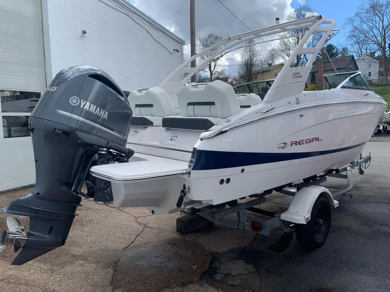 Slide: The Image of 2026 Regal LX4 boat interior with luxurious seating in a showroom. - 6