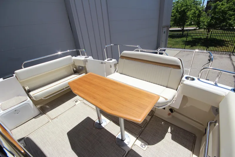 Slide: The Image of 2026 Ranger Tugs R-29 S boat deck with seating and wooden table. - 14