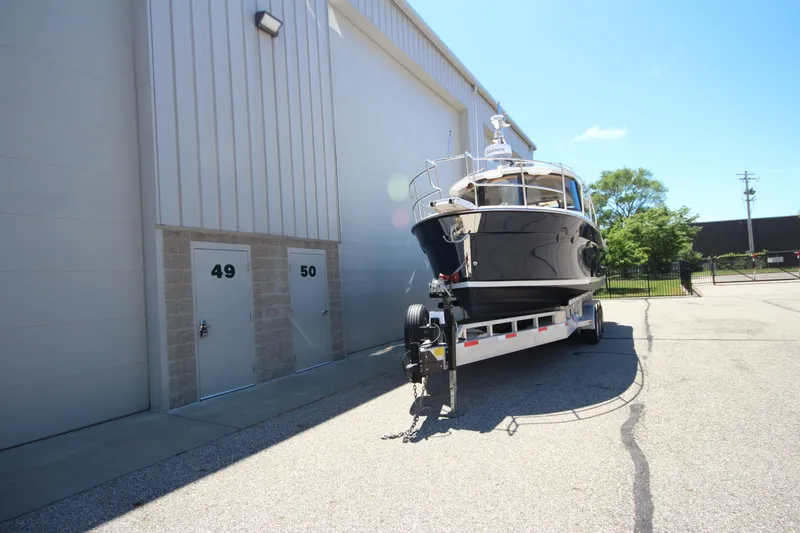 Slide: The Image of 2026 Ranger Tugs R-29 S boat on trailer outside storage facility. - 2