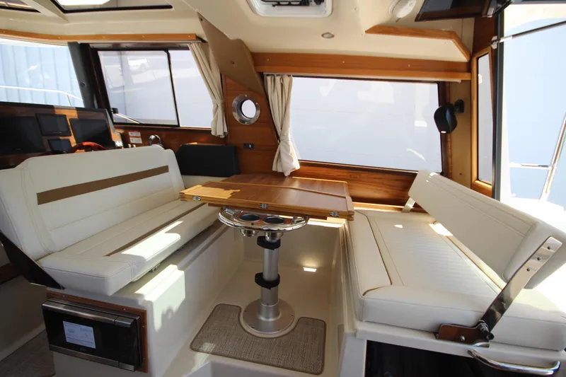 Slide: The Image of Interior of 2026 Ranger Tugs R-29 S with seating and wooden table. - 21