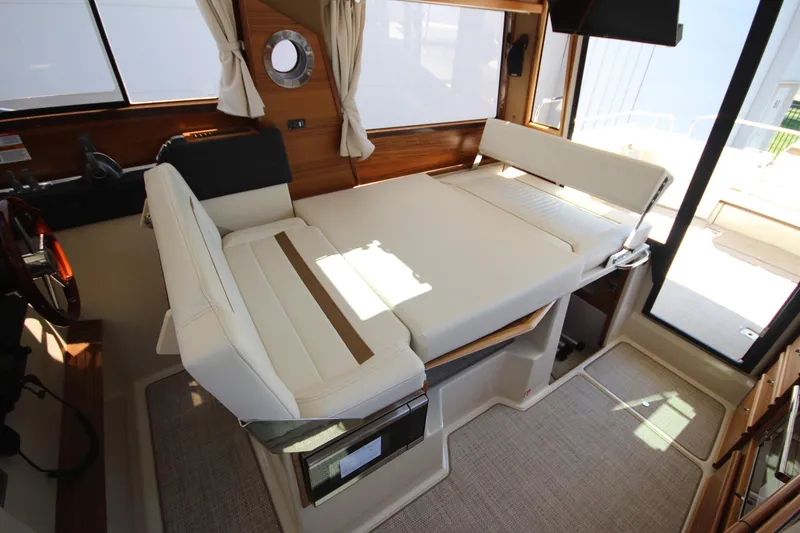 Slide: The Image of Interior of 2026 Ranger Tugs R-29 S with convertible seating and wooden accents. - 23