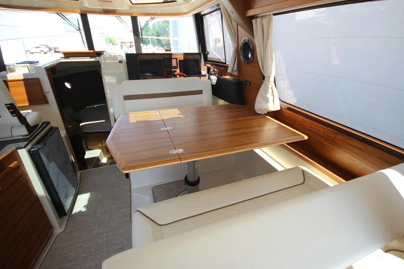 Slide: The Image of Interior of 2026 Ranger Tugs R-29 S, featuring a wooden dining table and seating area. - 24