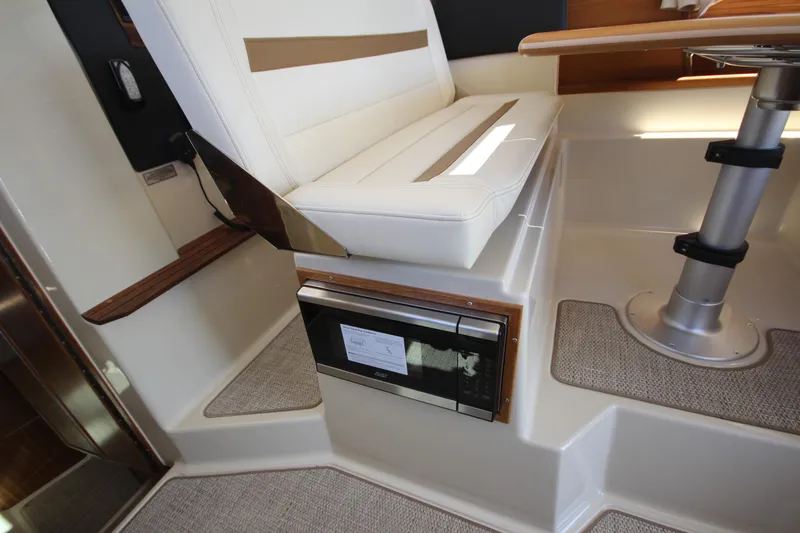 Slide: The Image of Interior of 2026 Ranger Tugs R-29 S, featuring seating and built-in microwave. - 27