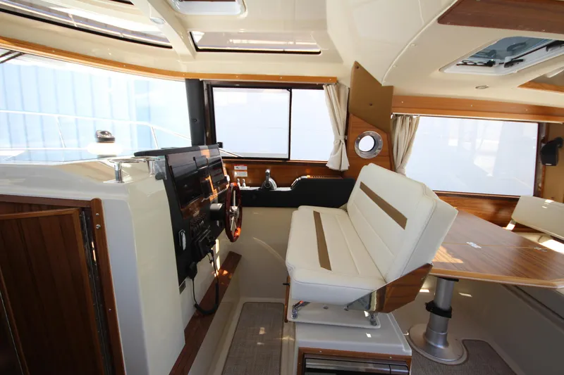 Slide: The Image of Interior of 2026 Ranger Tugs R-29 S boat, featuring helm and seating area. - 29
