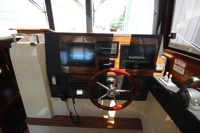 Slide: The Image of Helm of 2026 Ranger Tugs R-29 S with Garmin navigation displays and wooden steering wheel. - 30