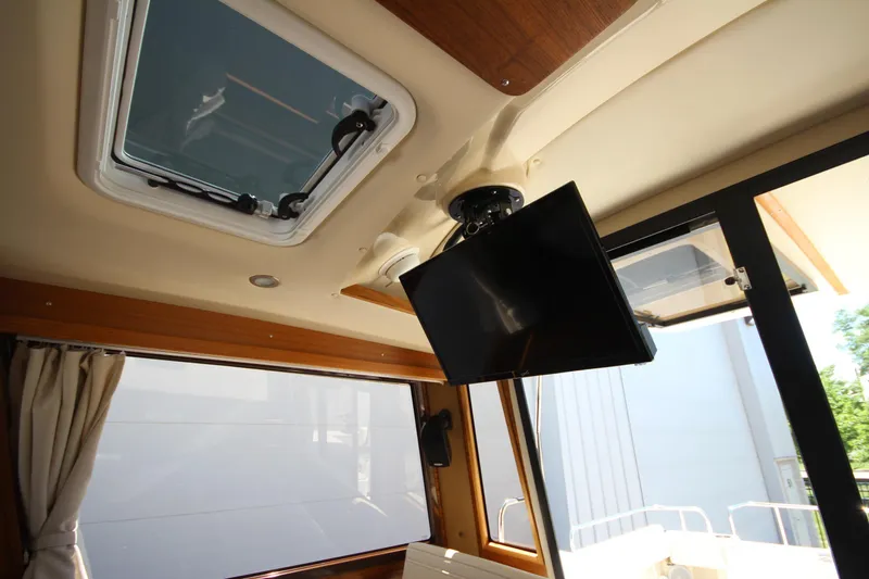 Slide: The Image of Interior of 2026 Ranger Tugs R-29 S with skylight and mounted TV. - 34