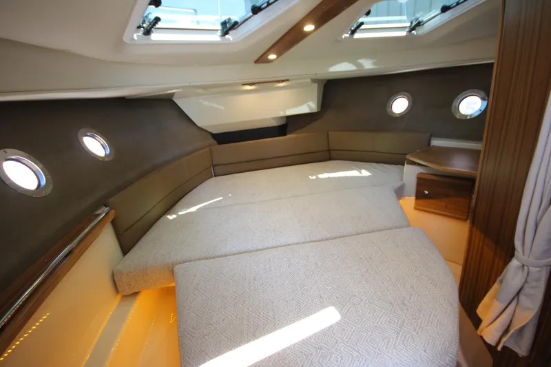 Slide: The Image of Luxurious interior cabin of 2026 Ranger Tugs R-29 S with elegant bedding and porthole windows. - 37