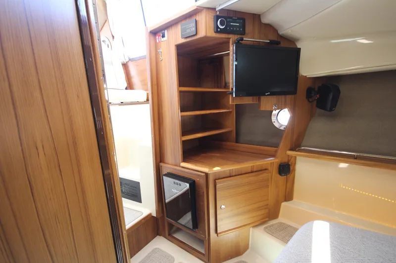 Slide: The Image of Interior of 2026 Ranger Tugs R-29 S, featuring wood cabinetry and a mounted TV. - 40