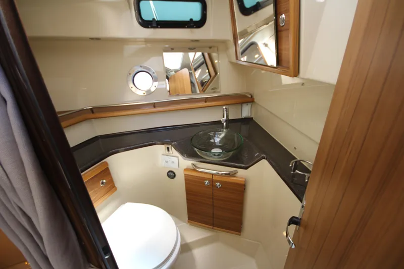 Slide: The Image of 2026 Ranger Tugs R-29 S bathroom with modern glass sink and wooden cabinetry. - 41