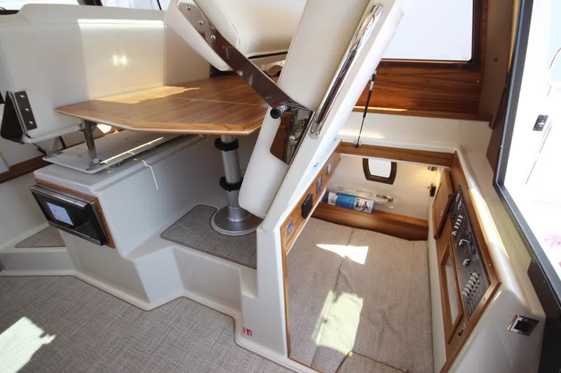 Slide: The Image of 2026 Ranger Tugs R-29 S interior with convertible seating and storage area. - 44