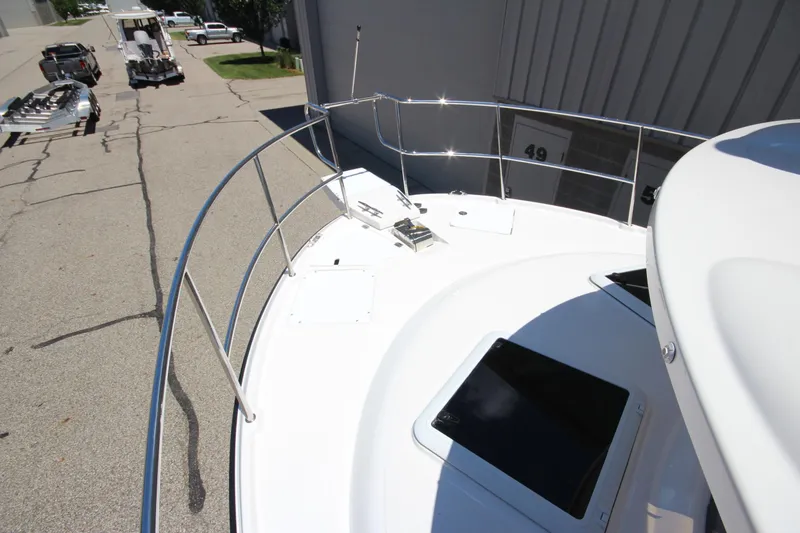 Slide: The Image of 2026 Ranger Tugs R-29 S boat deck with railing and hatch, parked near trailers. - 48