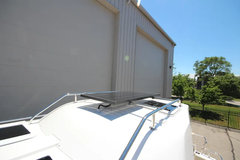 Slide: The Image of 2026 Ranger Tugs R-29 S with solar panel on roof, near industrial building. - 52