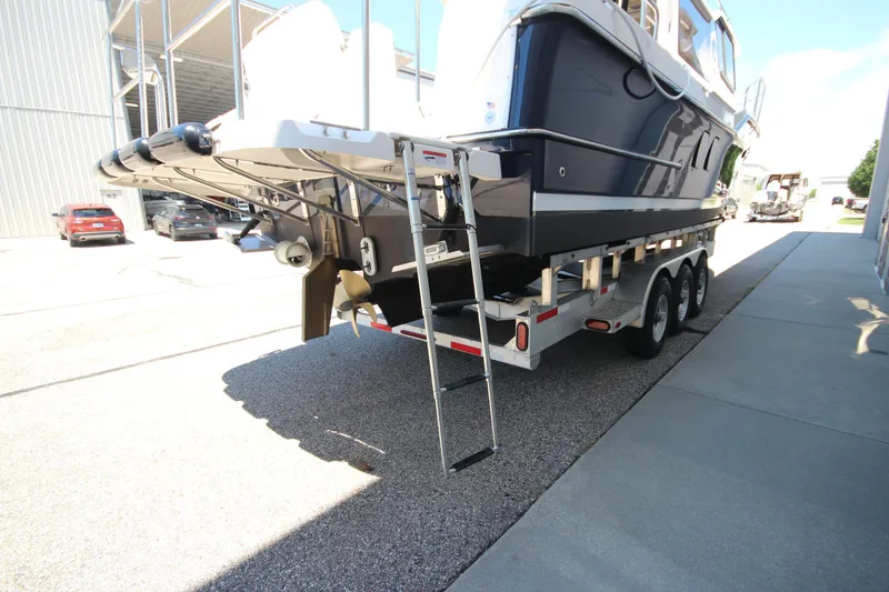 Slide: The Image of 2026 Ranger Tugs R-29 S on trailer, showcasing rear view and ladder. - 7