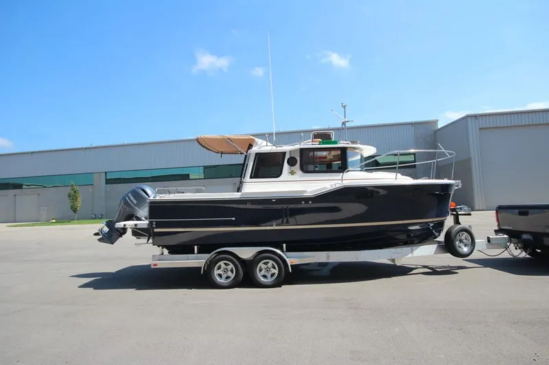 Slide: The Image of 2025 Ranger Tugs R-23 boat on a trailer in an industrial area. - 1