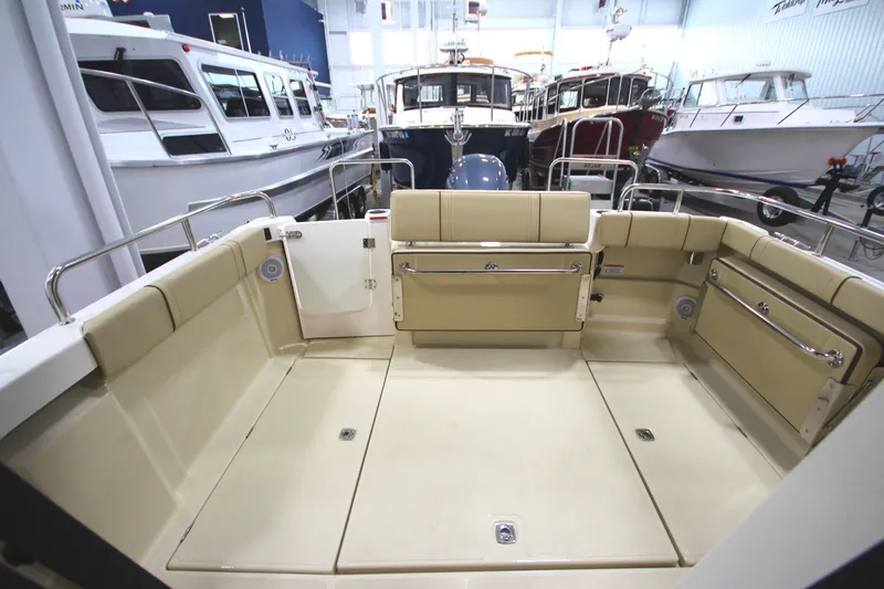 Slide: The Image of 2025 Ranger Tugs R-23 boat interior with beige seating and spacious deck. - 16