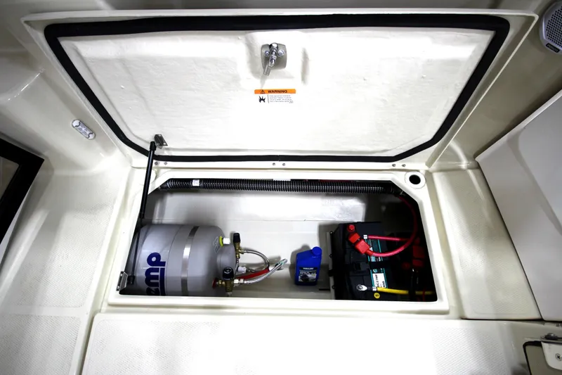 Slide: The Image of 2025 Ranger Tugs R-23 boat storage compartment with battery and equipment. - 17