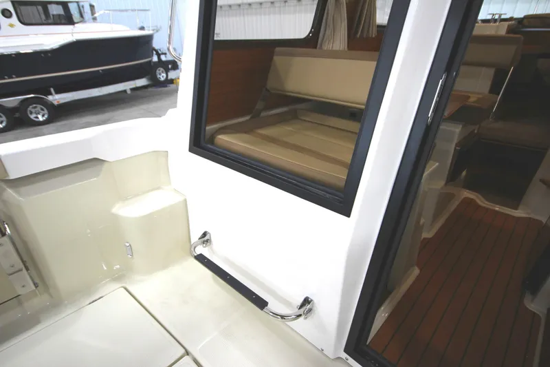 Slide: The Image of 2025 Ranger Tugs R-23 boat interior with seating and wooden flooring. - 22