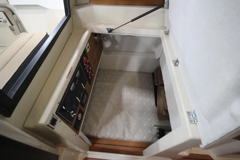 Slide: The Image of 2025 Ranger Tugs R-23 interior storage compartment with control panel. - 37