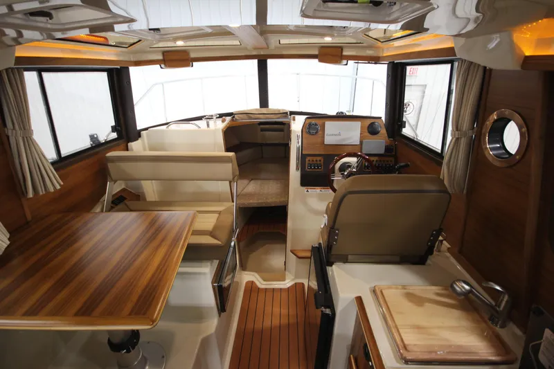 Slide: The Image of Interior of 2025 Ranger Tugs R-23 boat with wooden table, seating, and helm station. - 40