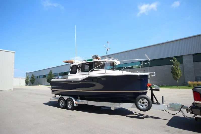 Slide: The Image of 2025 Ranger Tugs R-23 boat on a trailer in an industrial area. - 7