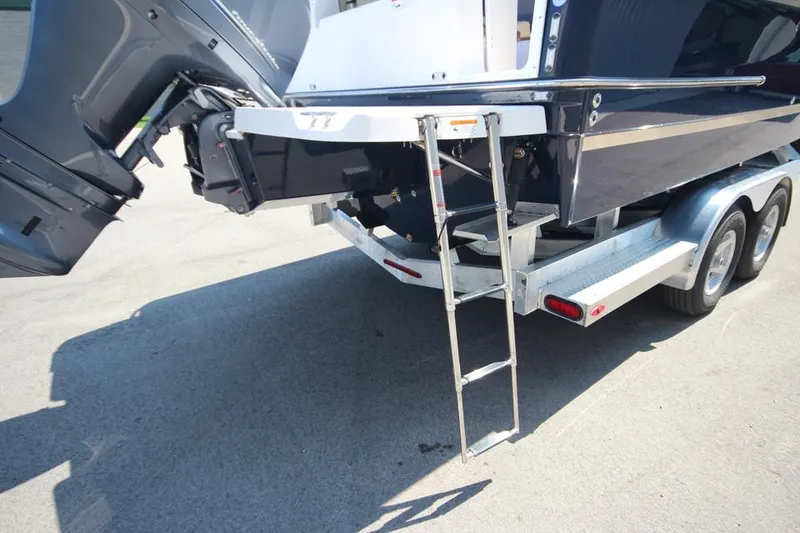 Slide: The Image of 2025 Ranger Tugs R-23 boat on trailer with outboard motor and boarding ladder. - 10