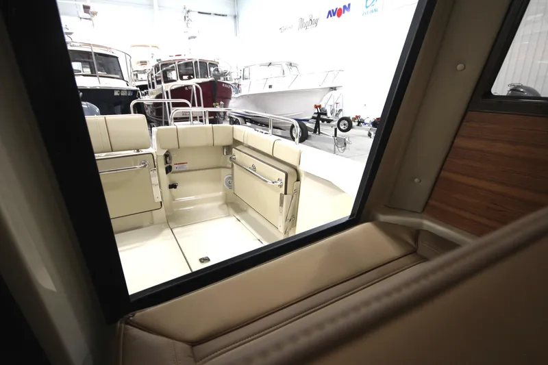 Slide: The Image of 2025 Ranger Tugs R-23 boat interior view, showcasing seating and deck area. - 23