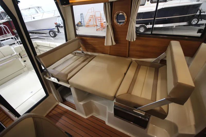 Slide: The Image of Interior of 2025 Ranger Tugs R-23 with convertible seating and wood accents. - 27