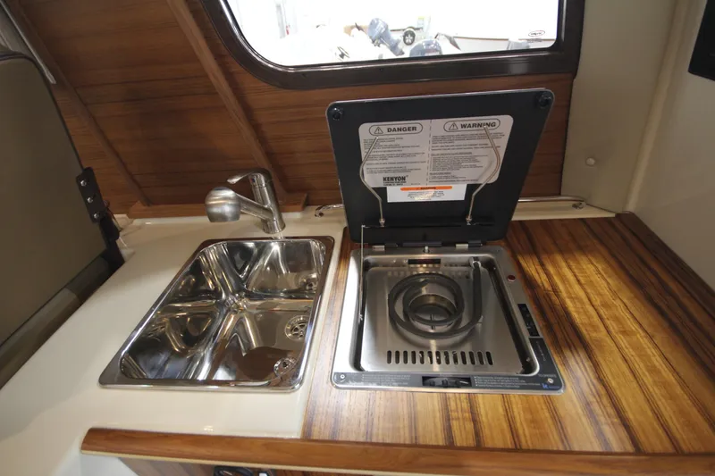 Slide: The Image of Compact kitchen area in 2025 Ranger Tugs R-23 boat with sink and stove. - 29