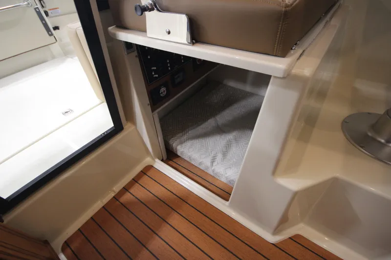 Slide: The Image of 2025 Ranger Tugs R-23 interior cabin with wood flooring and cushioned seating. - 34