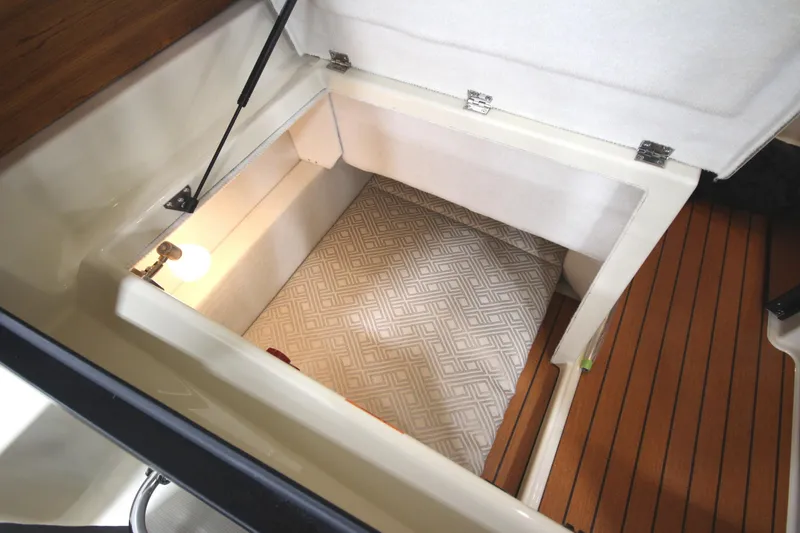 Slide: The Image of 2025 Ranger Tugs R-23 interior storage compartment with light and patterned flooring. - 35