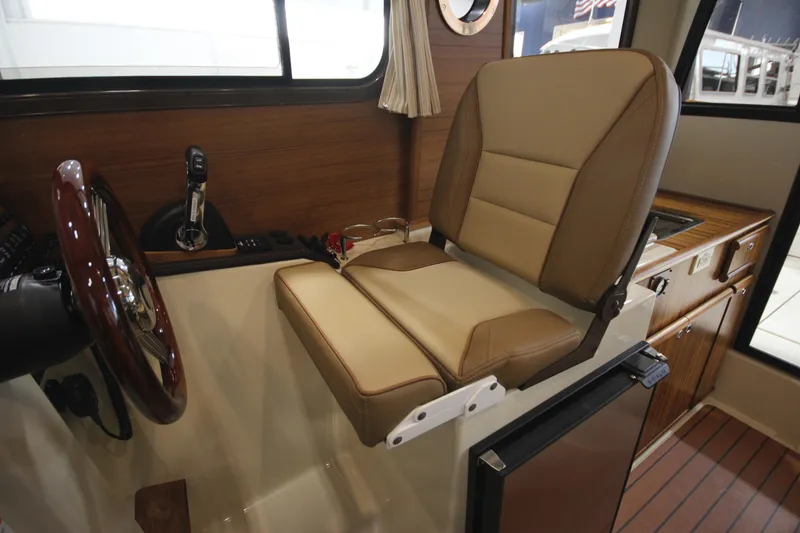 Slide: The Image of 2025 Ranger Tugs R-23 helm seat and control panel in cabin. - 44