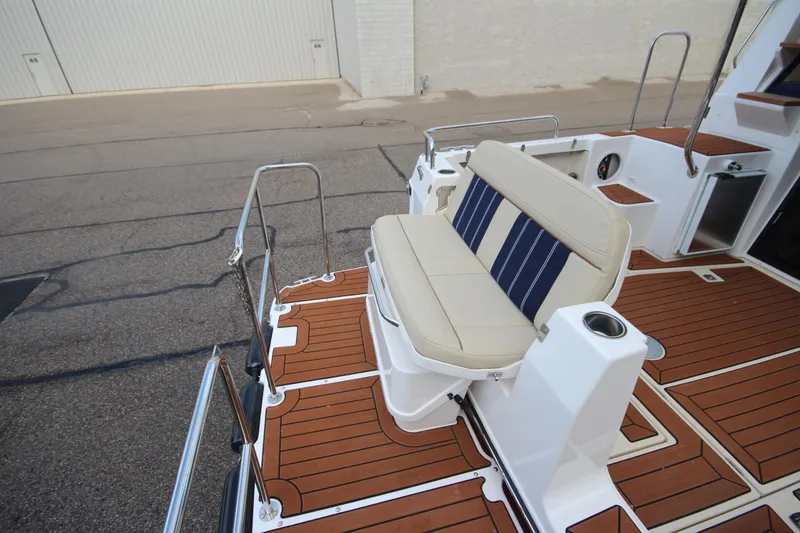 Slide: The Image of 2025 Ranger Tugs R-29 Command Bridge Luxury Edition with elegant deck seating and wood finish. - 10