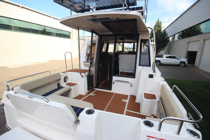 Slide: The Image of 2025 Ranger Tugs R-29 Command Bridge Luxury Edition with spacious deck and elegant wood finish. - 13