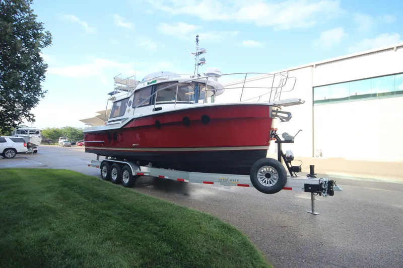 Slide: The Image of 2025 Ranger Tugs R-29 Command Bridge Luxury Edition on trailer, parked outdoors. - 2