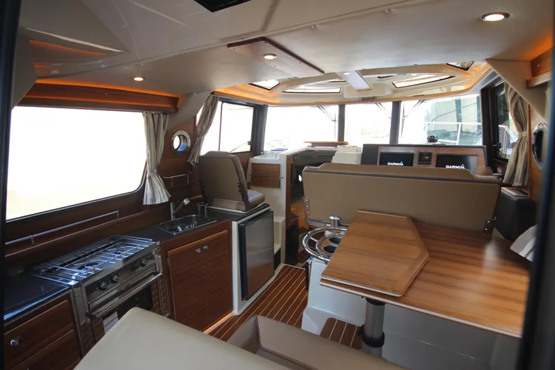 Slide: The Image of 2025 Ranger Tugs R-29 Command Bridge Luxury Edition interior with modern kitchen and navigation area. - 26