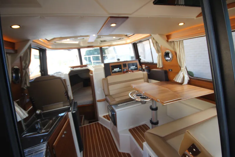 Slide: The Image of Interior of 2025 Ranger Tugs R-29 Command Bridge Luxury Edition, featuring elegant seating and wood finishes. - 27