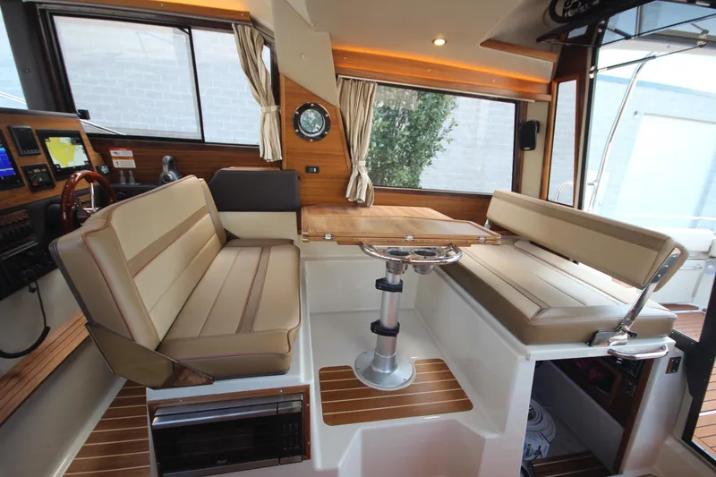 Slide: The Image of 2025 Ranger Tugs R-29 Command Bridge Luxury Edition interior with seating and navigation equipment. - 30