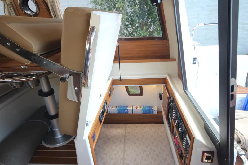 Slide: The Image of 2025 Ranger Tugs R-29 Command Bridge interior with luxury seating and control panel. - 33