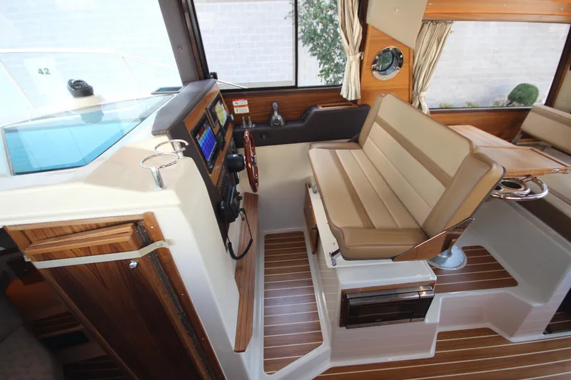 Slide: The Image of 2025 Ranger Tugs R-29 Command Bridge Luxury Edition interior with helm and seating area. - 38