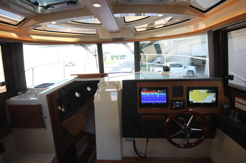 Slide: The Image of Interior view of 2025 Ranger Tugs R-29 Command Bridge Luxury Edition helm with navigation displays. - 39