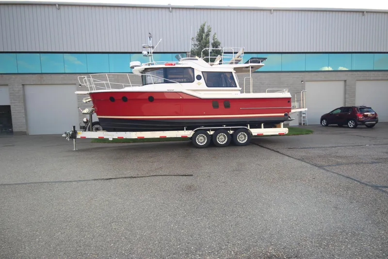 Slide: The Image of 2025 Ranger Tugs R-29 Command Bridge Luxury Edition on trailer, parked outside warehouse. - 4