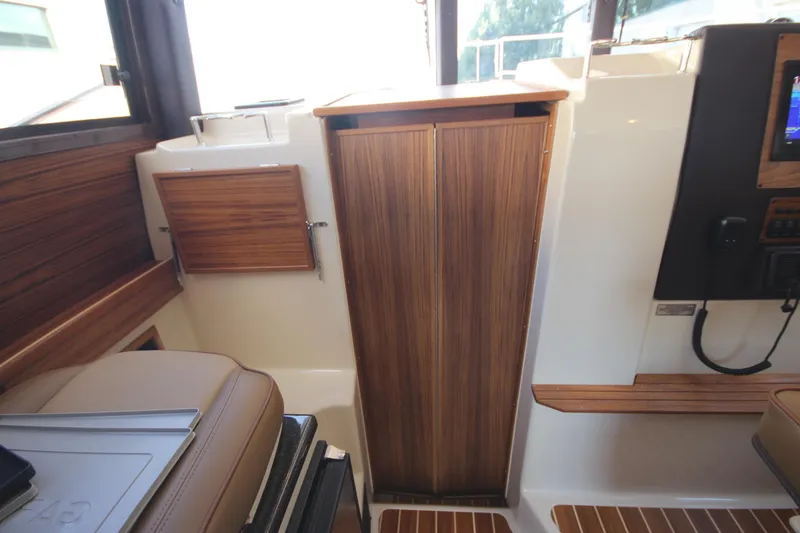 Slide: The Image of Interior of 2025 Ranger Tugs R-29 Command Bridge, featuring elegant wood paneling and modern design. - 42