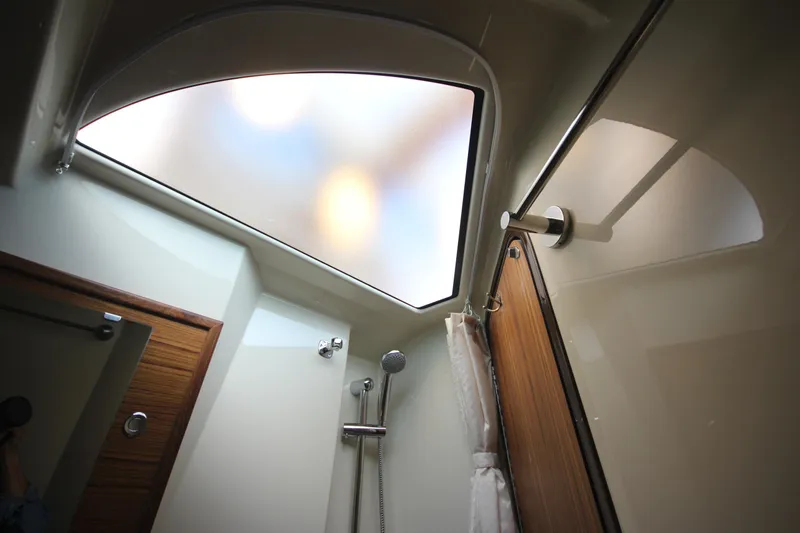 Slide: The Image of 2025 Ranger Tugs R-29 Command Bridge Luxury Edition bathroom with skylight and modern shower. - 48