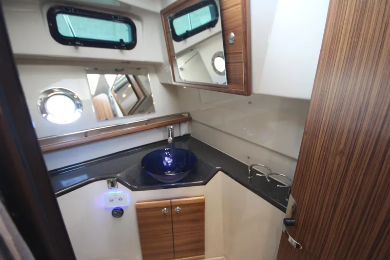 Slide: The Image of Luxurious bathroom in 2025 Ranger Tugs R-29 Command Bridge, featuring modern sink and wood accents. - 49