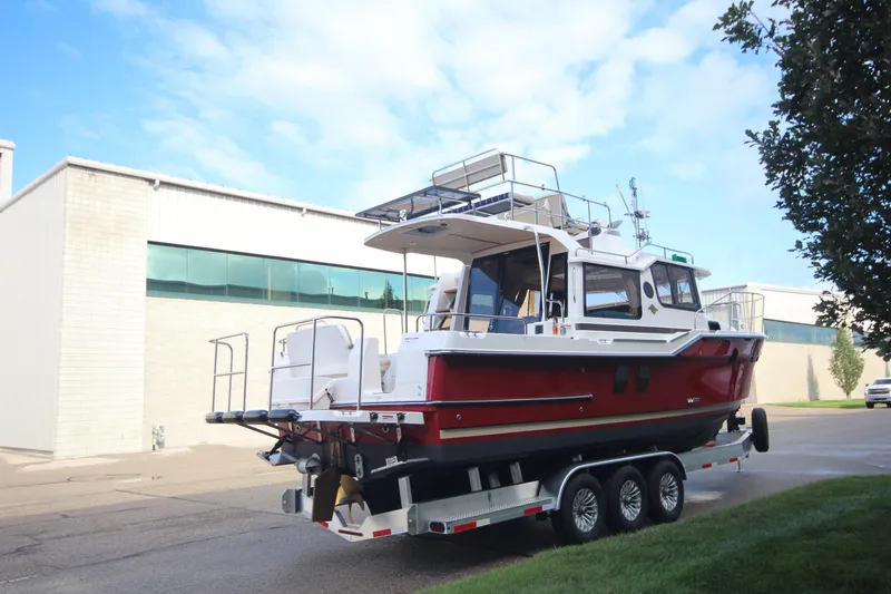 Slide: The Image of 2025 Ranger Tugs R-29 Command Bridge Luxury Edition on trailer, parked near industrial building. - 5