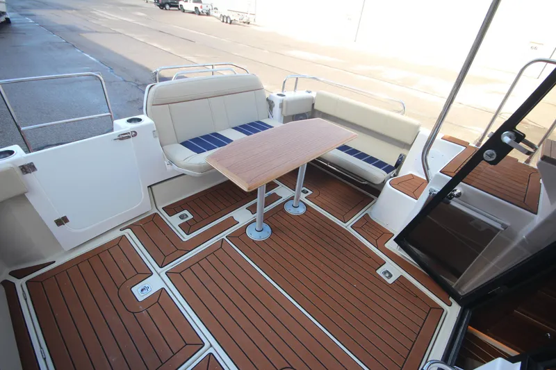 Slide: The Image of 2025 Ranger Tugs R-29 Command Bridge Luxury Edition deck with seating and table. - 50