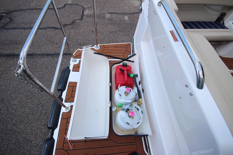 Slide: The Image of 2025 Ranger Tugs R-29 Command Bridge storage area with propane tanks and fuel container. - 9